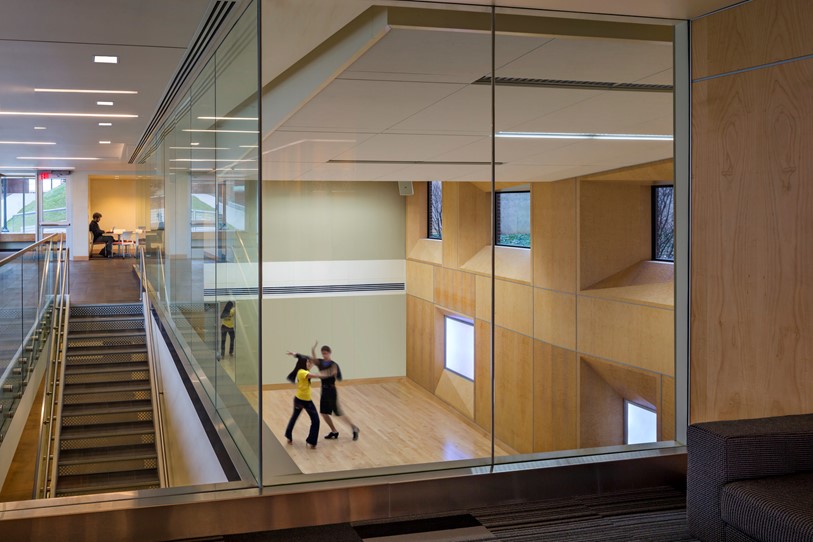 At the University of Michigan, a floor above what had been a mechanical support space was removed, creating both a day-lit two-story dance studio and a two-story lounge with glass windows, bringing natural light into what was once a dark utility space.